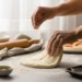 Homemade pizza dough being shaped by hand on a floured surface, made in 30 minutes for an easy pizza night recipe.