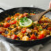 One-pan paella with saffron rice, seafood, and vegetables, colorful and ready to serve.