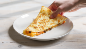 Budget-friendly cheese and vegetable quesadillas cut into slices, quick meal for feeding a crowd.