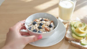 Diabetic-friendly breakfast with eggs, whole grain, berries, and nuts on plate for blood sugar control