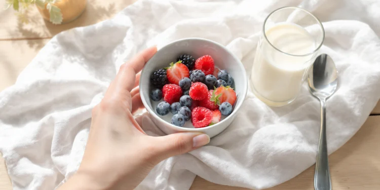Healthy breakfast bowl with oatmeal, berries, nuts for weight loss on wooden table