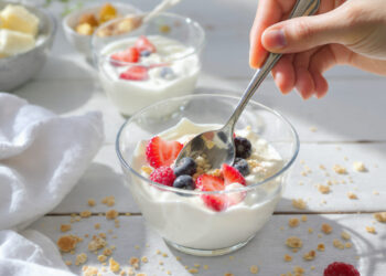 Healthy yogurt parfait breakfast with berries, granola and honey - quick morning meal