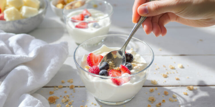 Healthy yogurt parfait breakfast with berries, granola and honey - quick morning meal