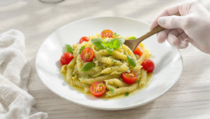 Pesto pasta salad with cherry tomatoes, quick vegetarian dish served fresh or chilled.