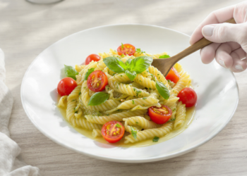 Pesto pasta salad with cherry tomatoes, quick vegetarian dish served fresh or chilled.