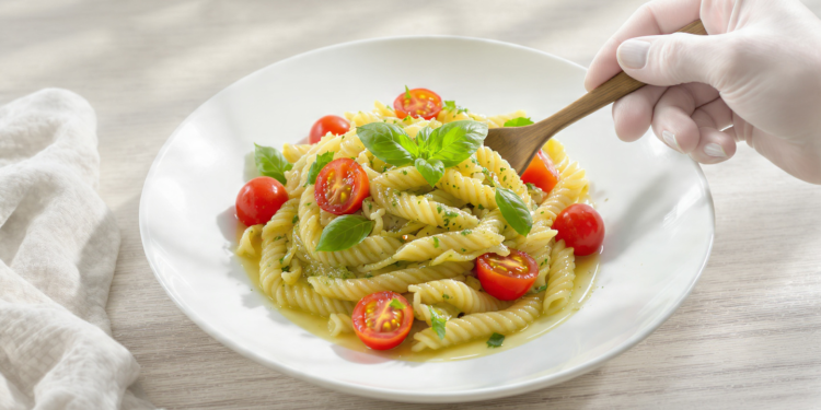 Pesto pasta salad with cherry tomatoes, quick vegetarian dish served fresh or chilled.