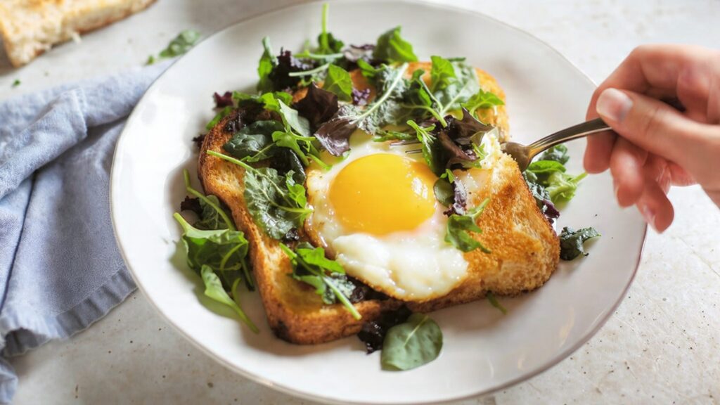 Sunny-side up egg toast with sautéed spinach and herbs - healthy breakfast recipe