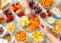 Simple picnic food ideas for kids including sandwiches, fruit, and finger foods on a checkered blanket