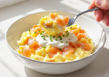 Quick healthy low-carb breakfast with eggs, avocado, smoked salmon, and fresh greens on a white plate.