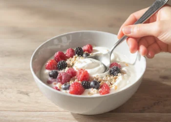 Quick healthy breakfast recipes for gut health with yogurt, berries, avocado toast, and lemon water on a white kitchen table.