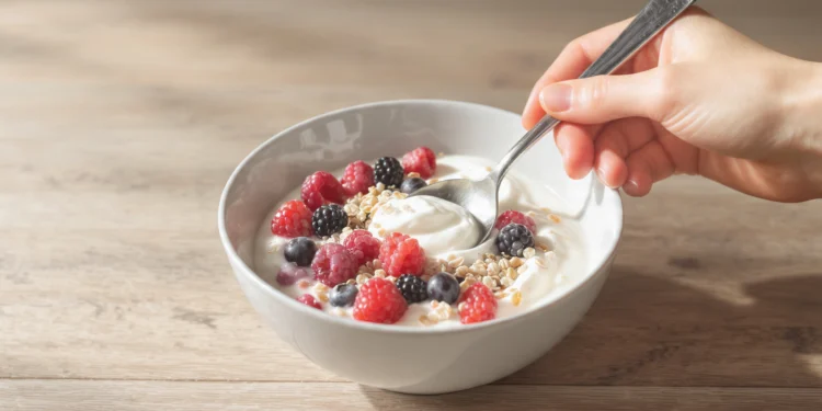 Quick healthy breakfast recipes for gut health with yogurt, berries, avocado toast, and lemon water on a white kitchen table.
