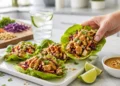Grilled chicken lettuce wraps on a neutral surface, shown at a 45-degree angle.